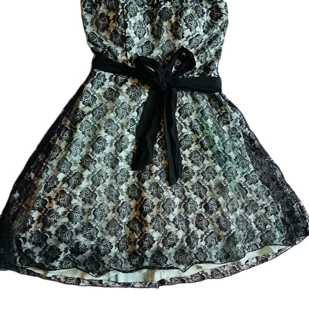 Short black lace dress with mint green trim and bow belt
